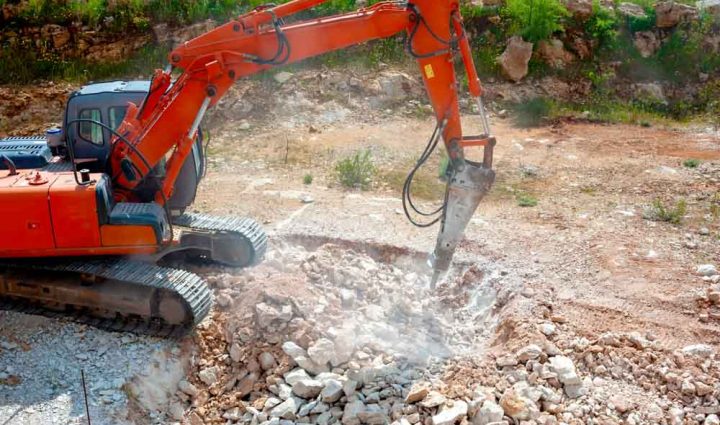Close-up of a heavy-duty construction excavator machine crushing stones on a construction site