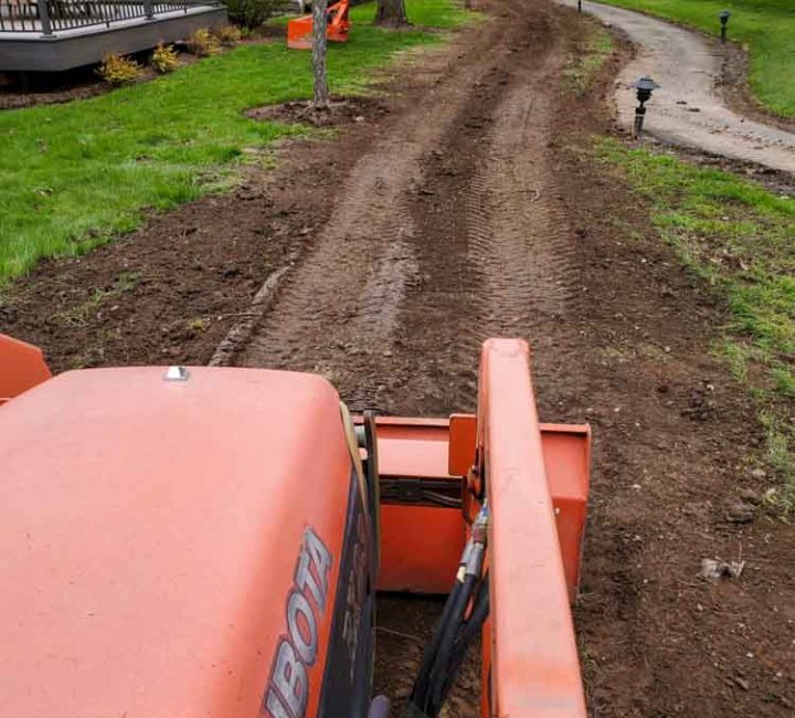 grading a new sidewalk using a mini Kubota bulldozer
